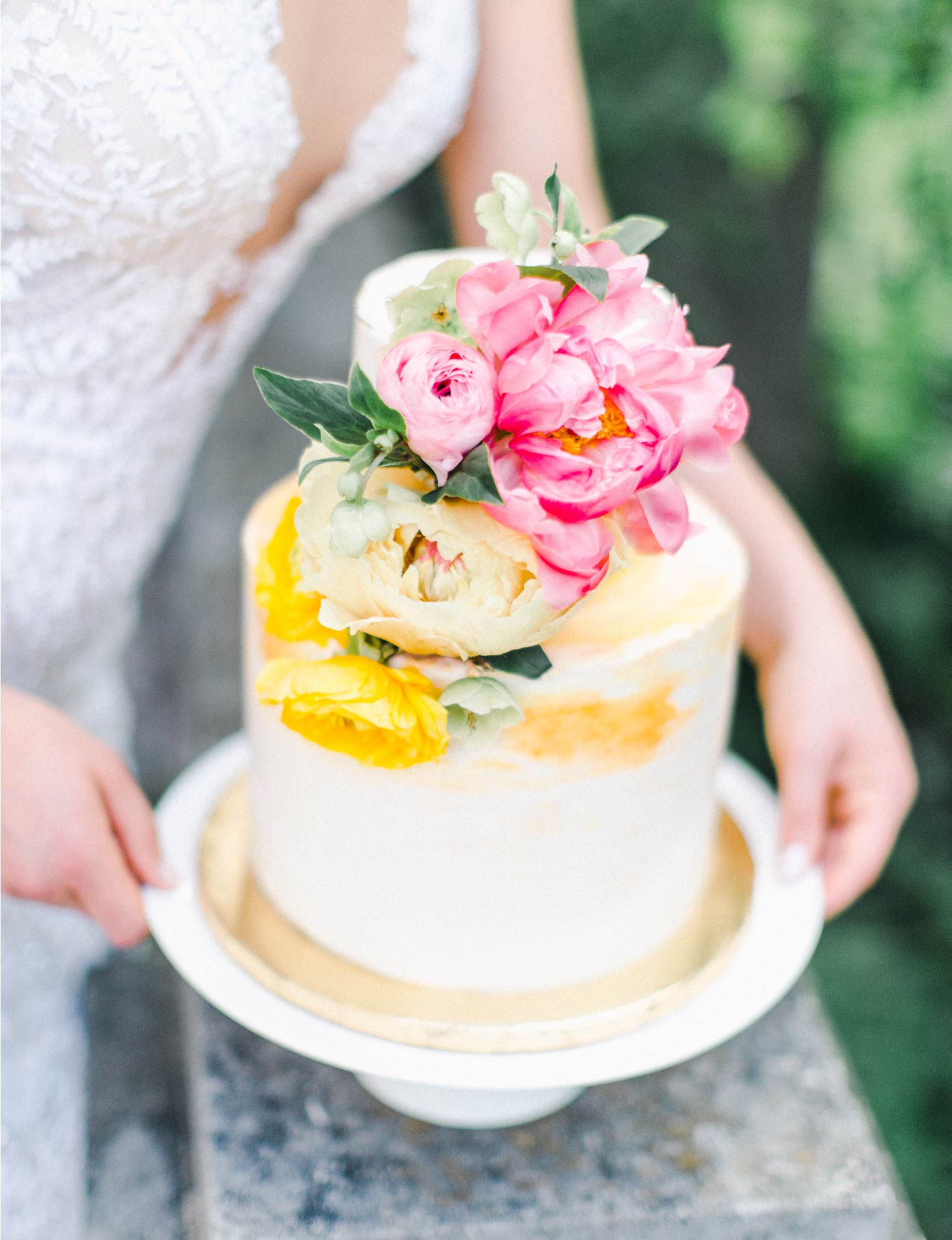 Close up of wedding cake topped with pink flowers